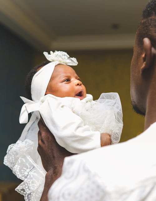 A Man Carrying A Baby Girl