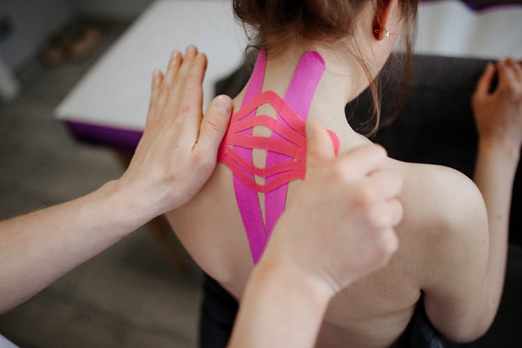 Close-up Of Person Taping Client Back