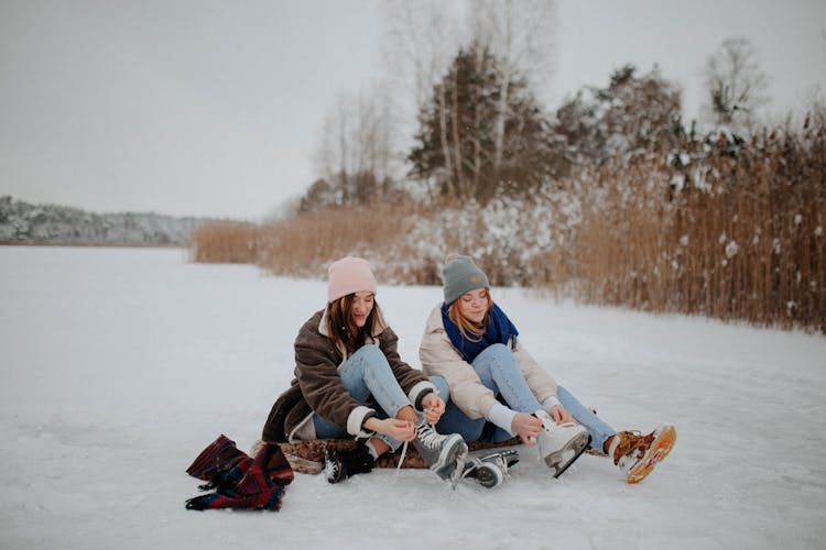 Photo Of Women Putting On Ice Skating Shoes