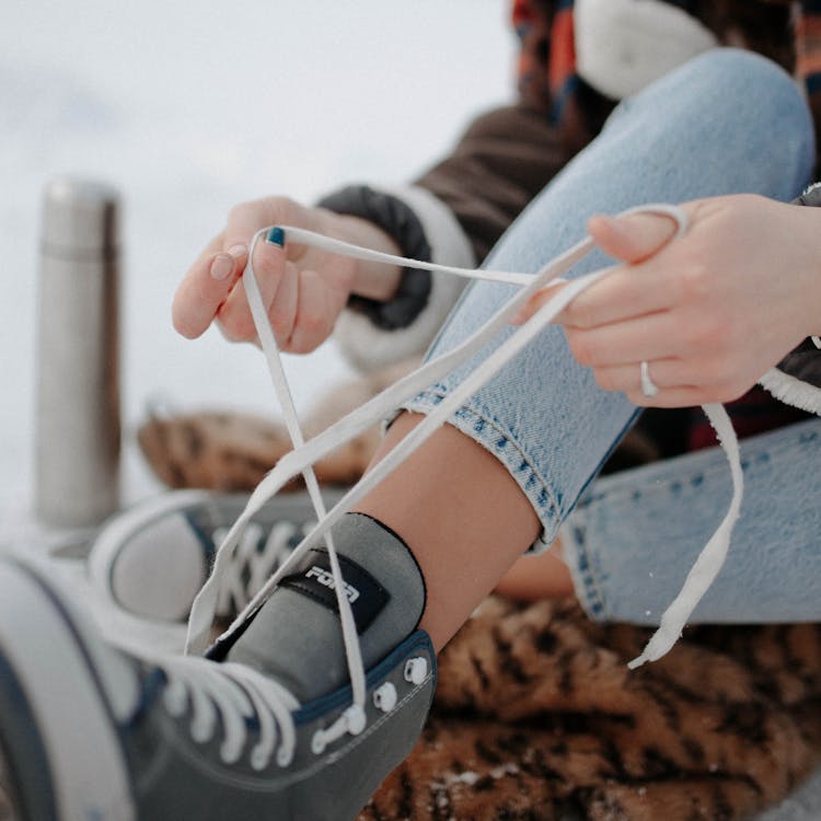 Photo Of A Person Tying The Laces Of A Shoe