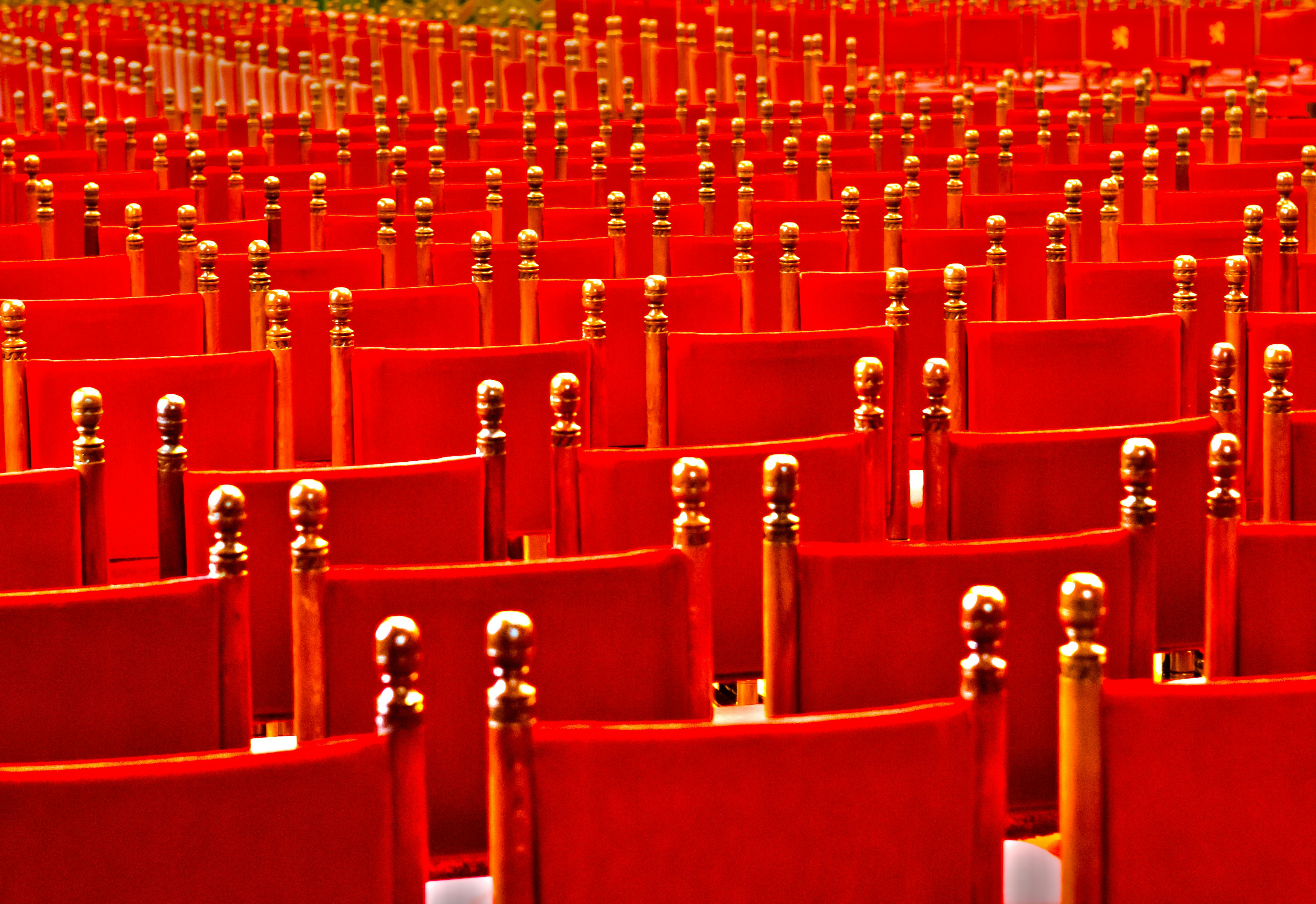 Free Vibrant red rows of empty chairs in an auditorium setting, perfect for event imagery. Stock Photo