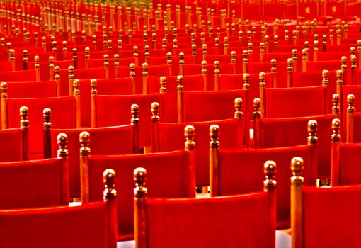 Vibrant red rows of empty chairs in an auditorium setting, perfect for event imagery.