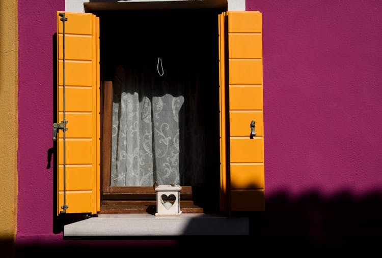 Brightly Colored Window Shutters On Pink Wall