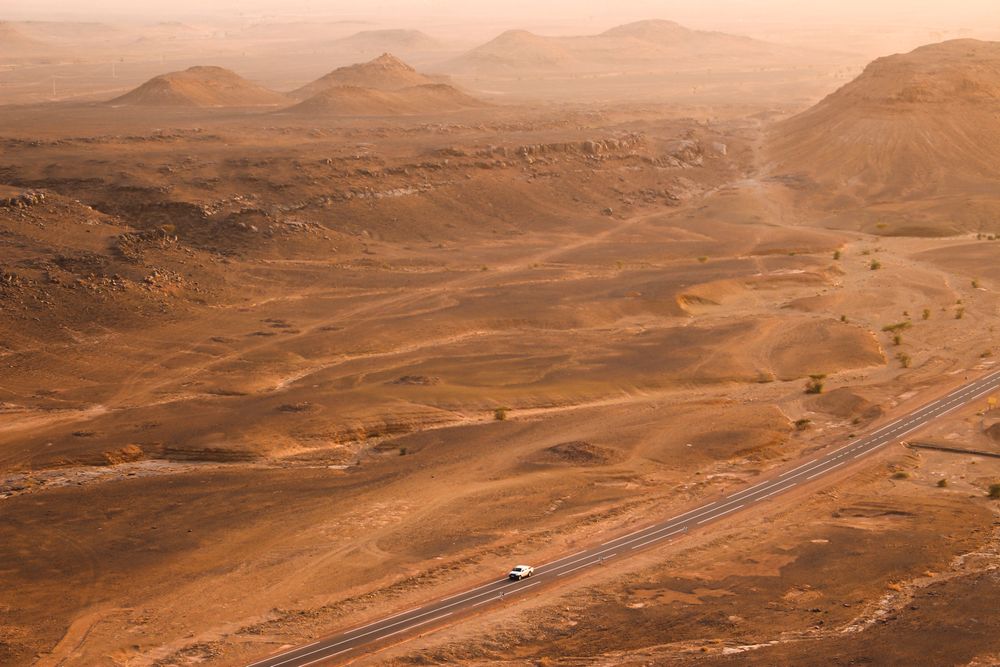 Car travelling on a desert road near Tagounite, Morocco