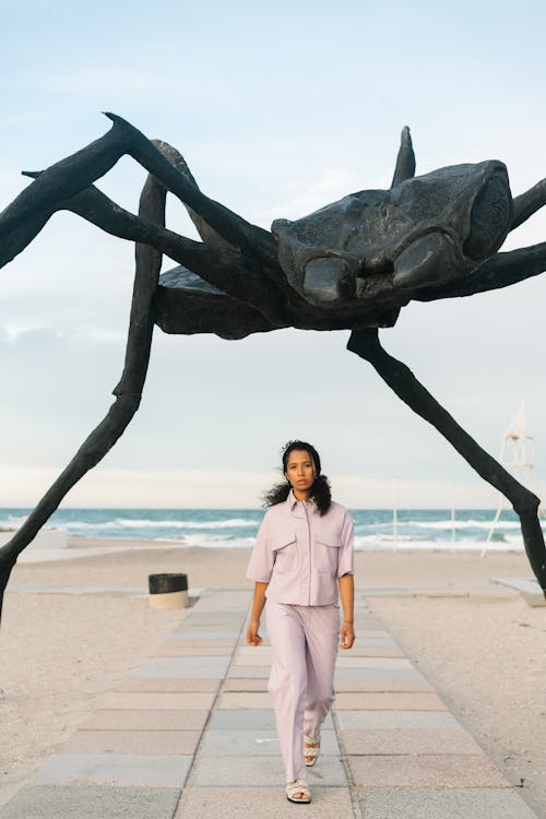 A Woman Walking under a Sculpture of a Spider