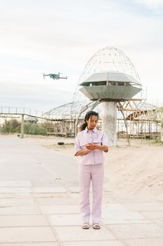Stylish woman interacts with technology in a modern urban outdoor setting.