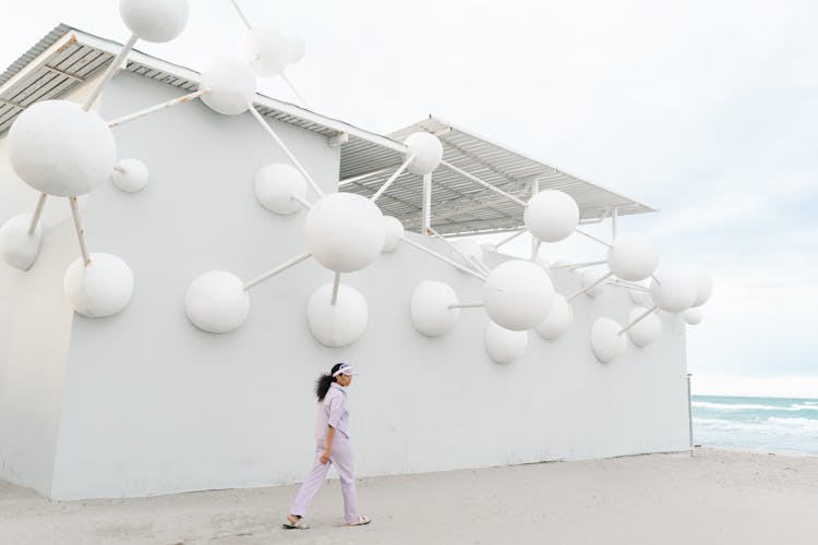 Woman Walking Beside An Abstract Designed Wall