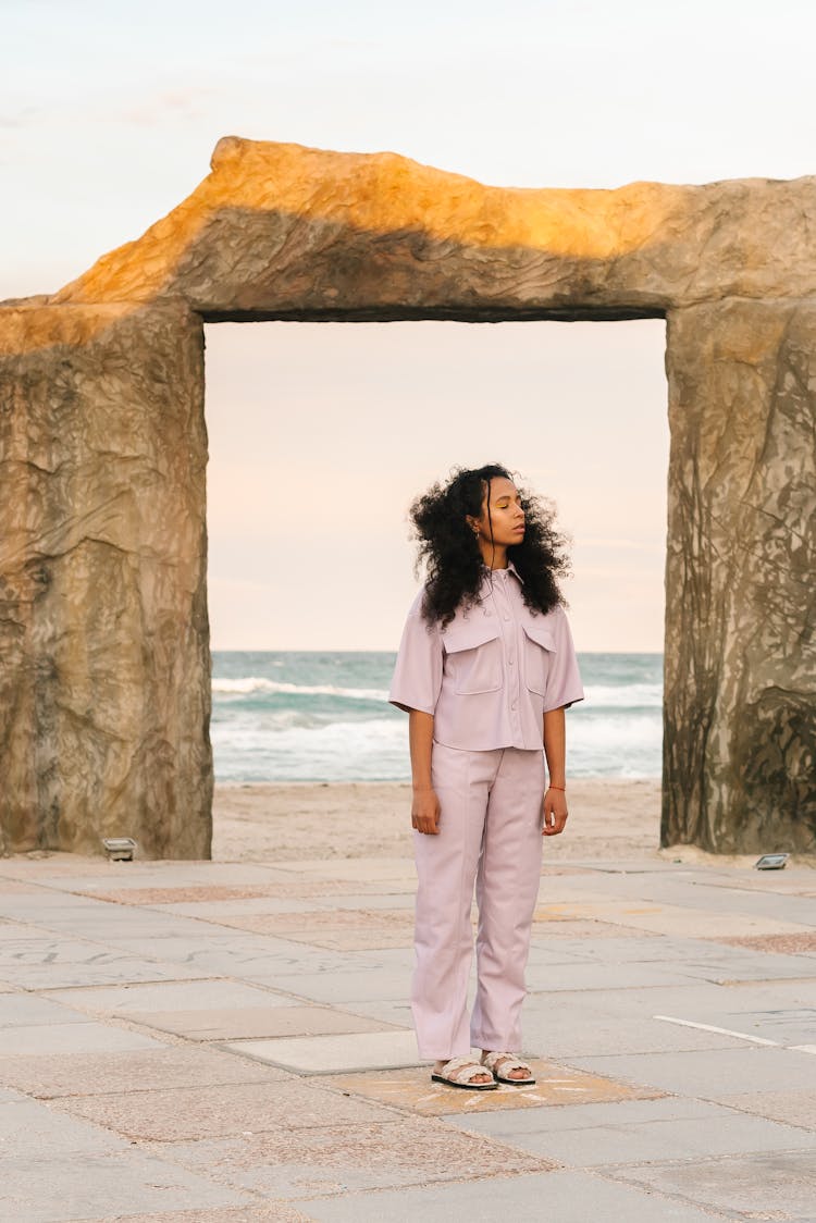 A Woman In A Pink Outfit By The Beach