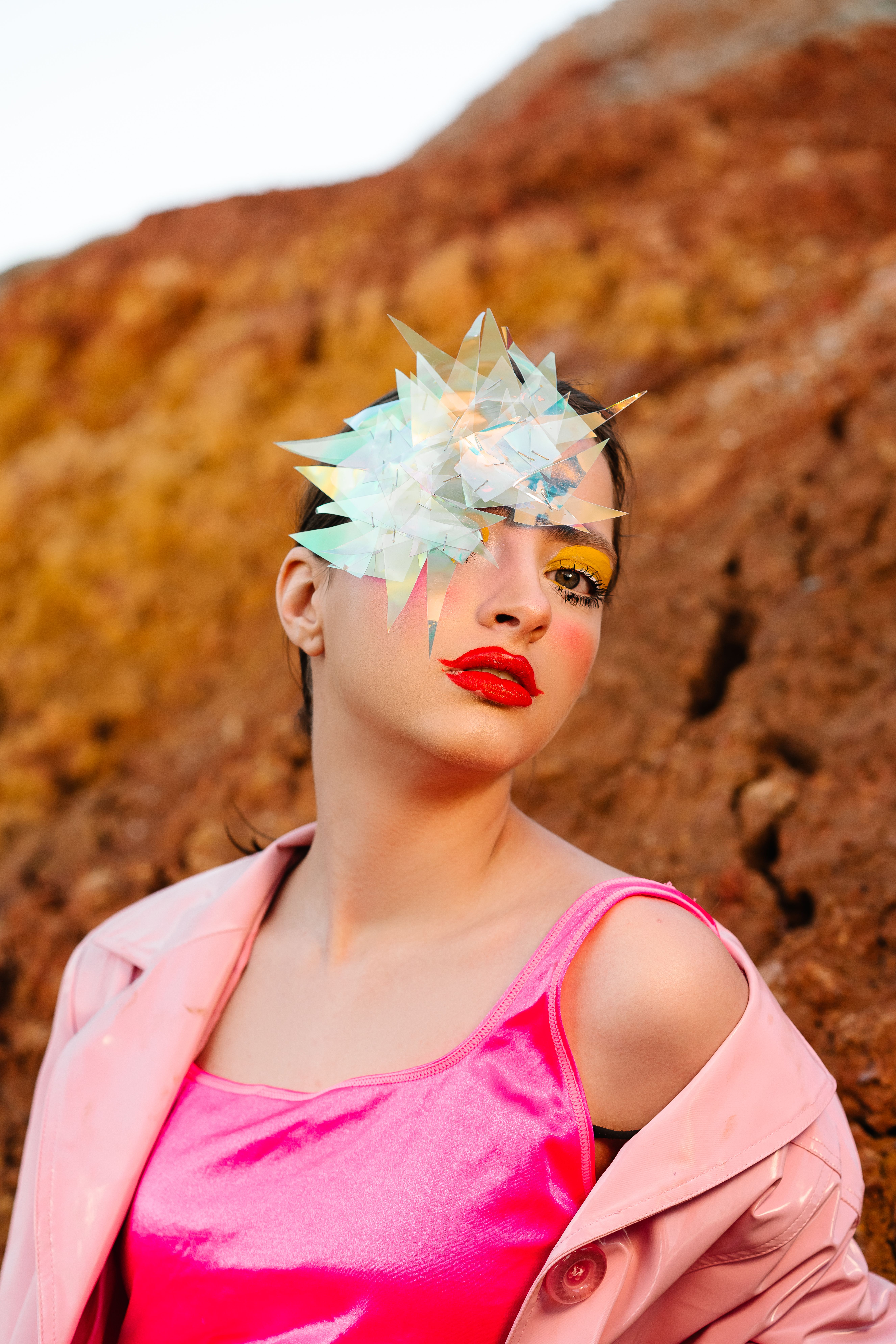 Stylish model with balloon against rough rock · Free Stock Photo