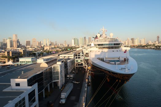 Aerial view of a cruise ship docked at Miami Beach port with a city skyline backdrop.