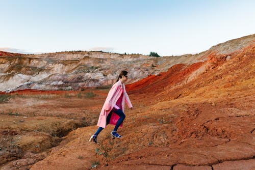 Woman Wearing a Pink Coat and High Heels Walking Uphill