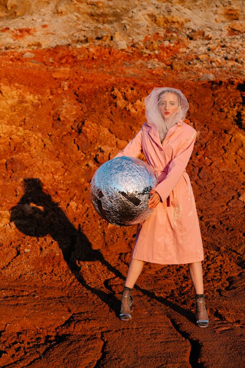 Free A Stylish Woman Holding a Silver Ball Stock Photo