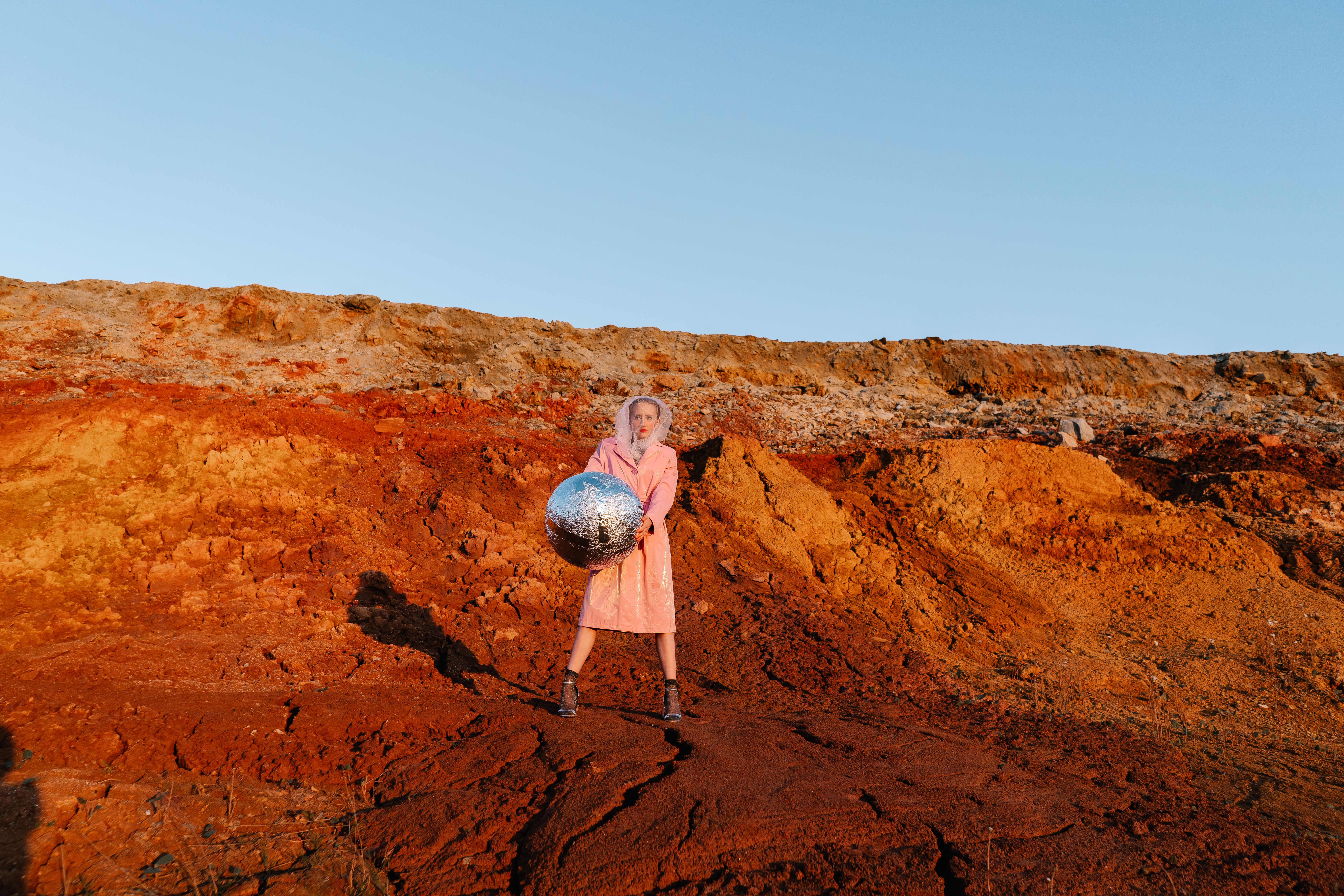 [ColoSach]-stylish-model-posing-with-a-disco-ball-in-a-barren-desert-setting.
