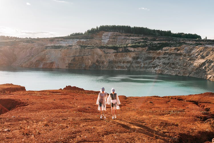 People Wearing Raincoat Standing Near A Lake 