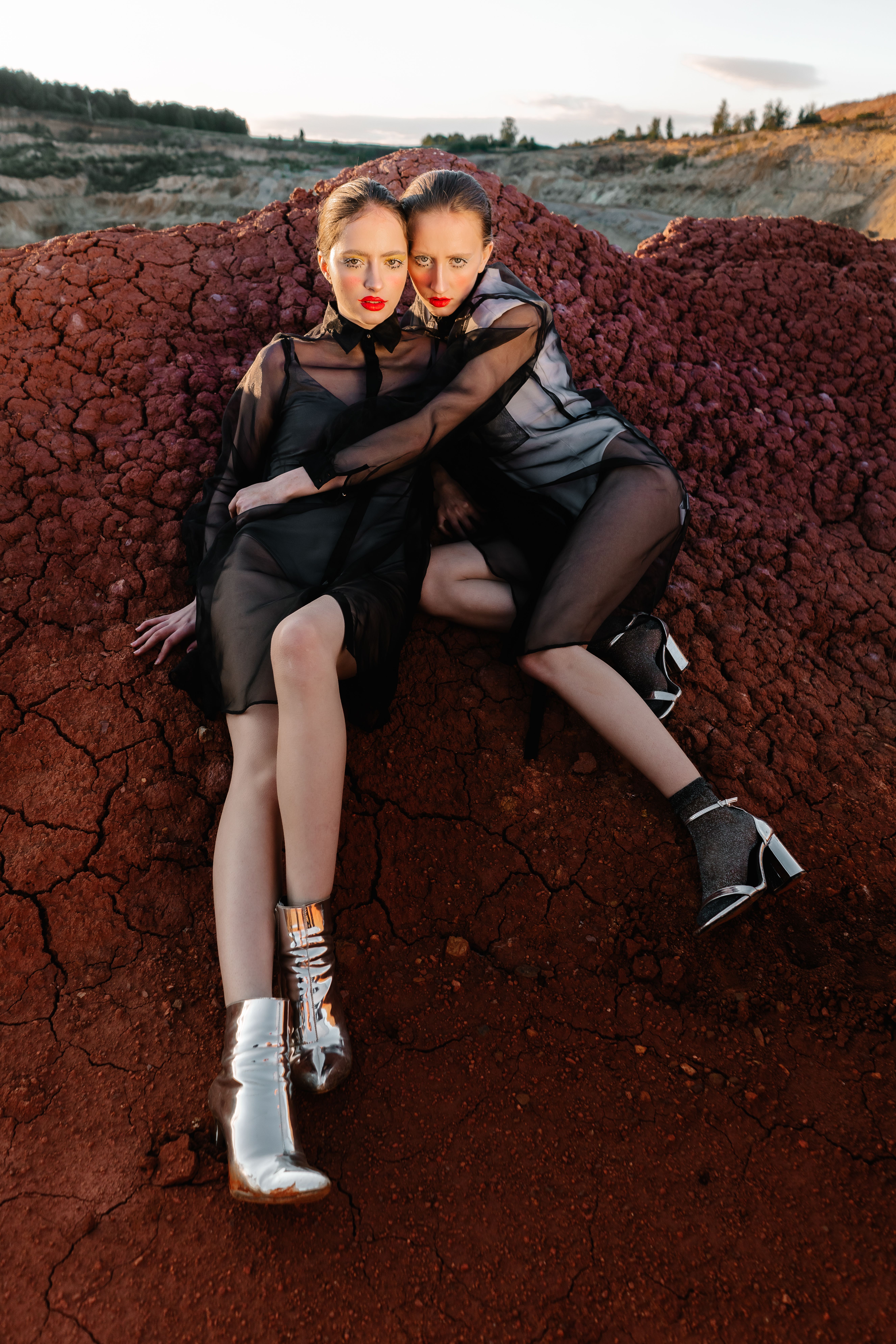 Women in Mesh Dresses Seating on a Red Rock · Free Stock Photo