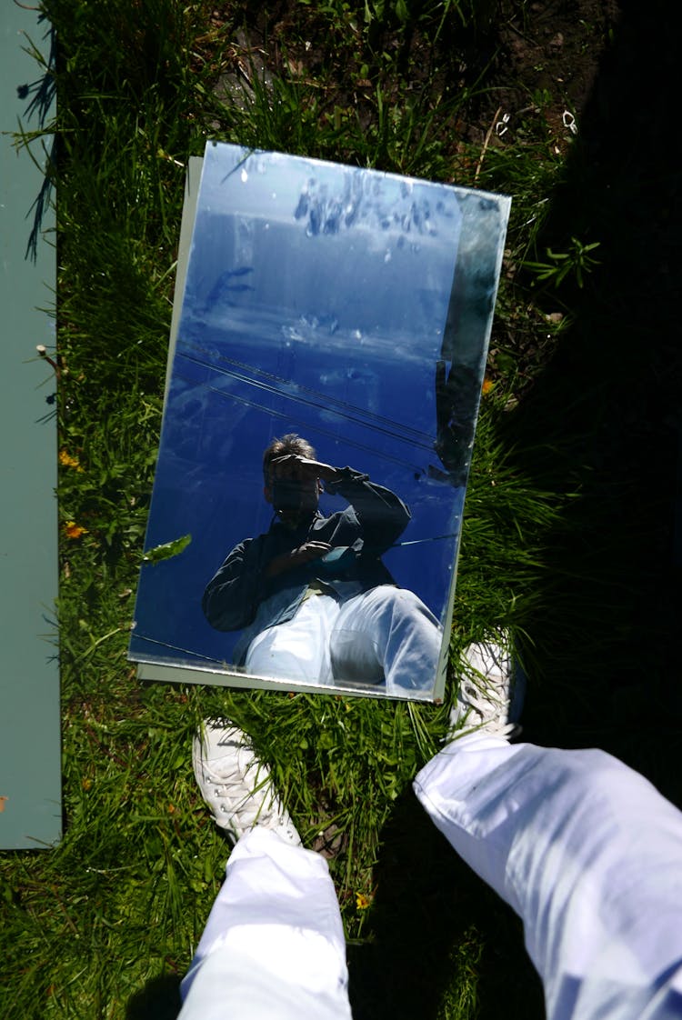 Person Taking Photo In Mirror On Grass