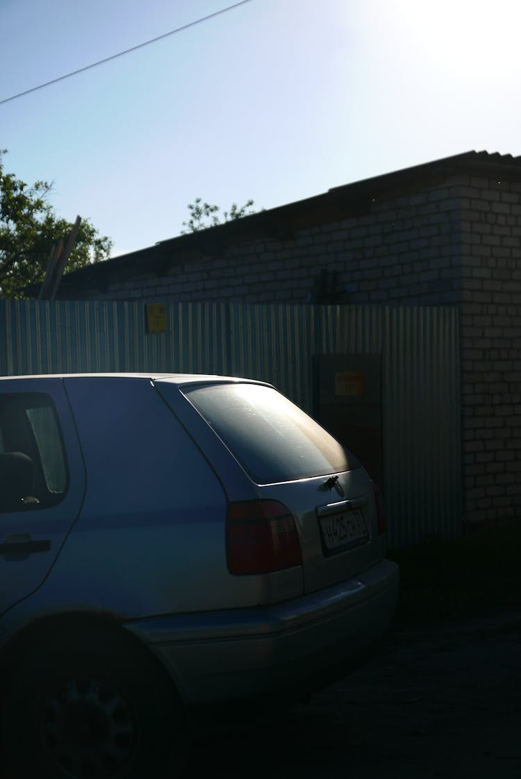 Old Car Parked By Garage Gate