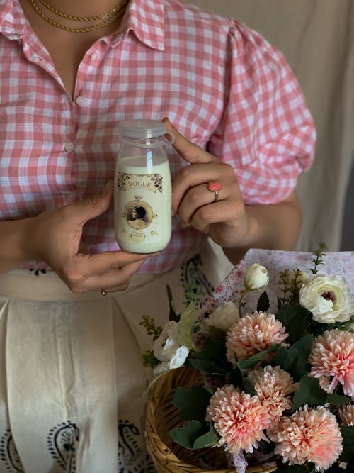 Crop woman with glass jar of milk