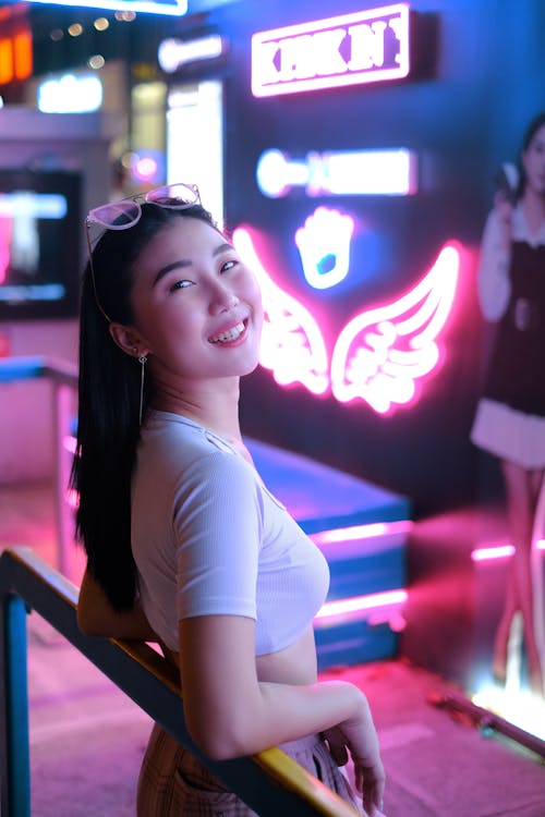 A Smiling Woman Posing on Metal Railing