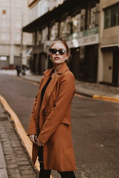 Stylish woman wearing sunglasses and coat in a New York City street.