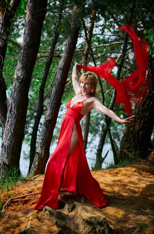 Free Woman Wearing a Red Dress Standing Near Trees Stock Photo