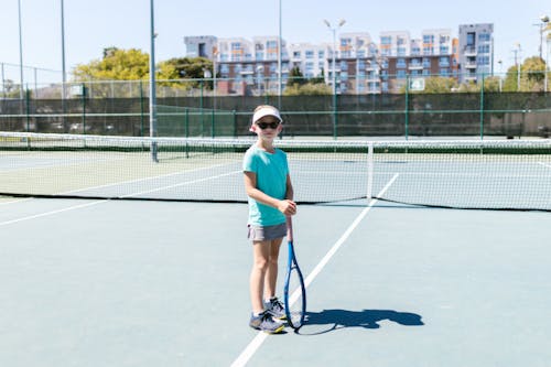Free Girl in Sportswear Holding Her Tennis Racket Stock Photo