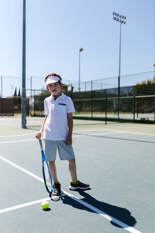 Free Boy in Sportswear Standing on the Tennis Court Stock Photo
