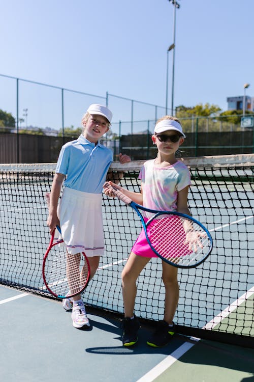 Free Girls Wearing Sportswear Standing by the Tennis Net Stock Photo
