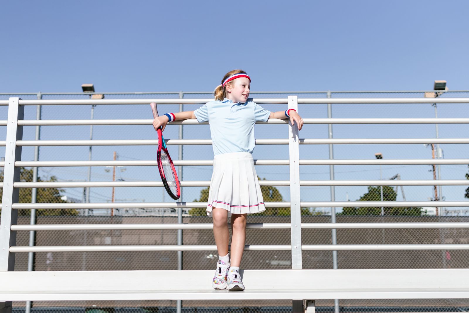Person holding a tennis racquet with wrist and forearm engaged outdoors