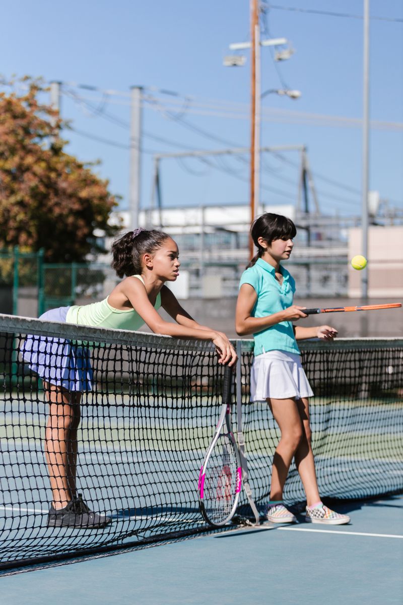 Two junior players talking at the net during practice