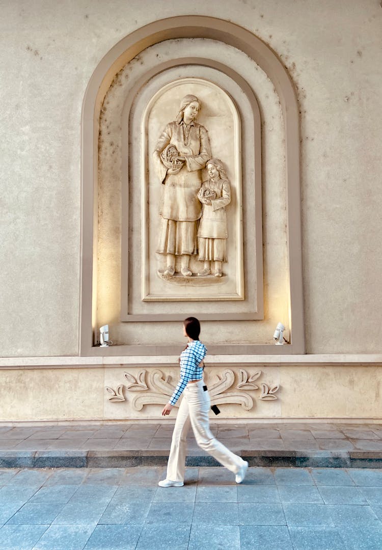 Woman Walking Under Relief Of Mother And Child