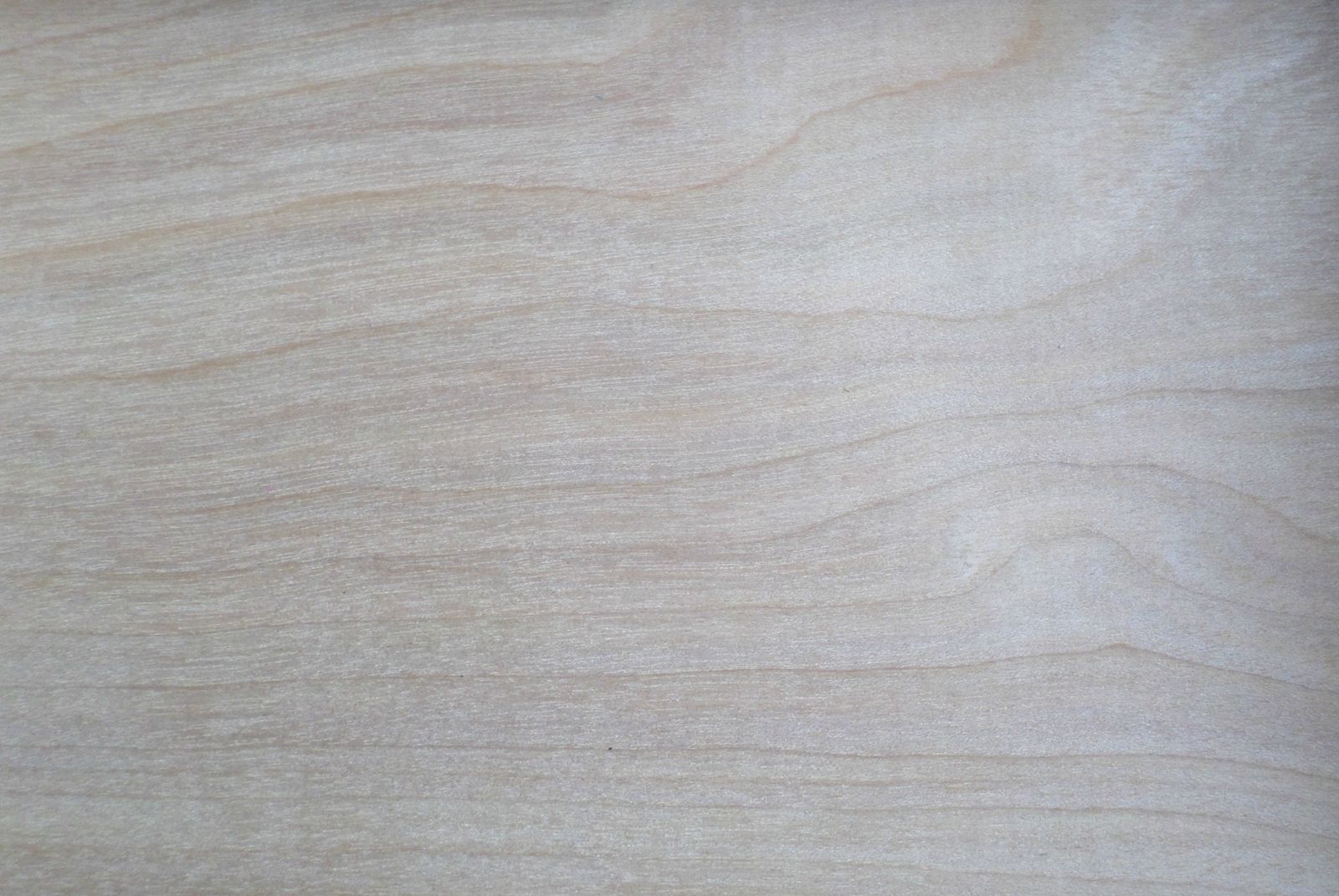 Close-up of light wood grain, evoking the wood-as-canvas surface where knife furrows live