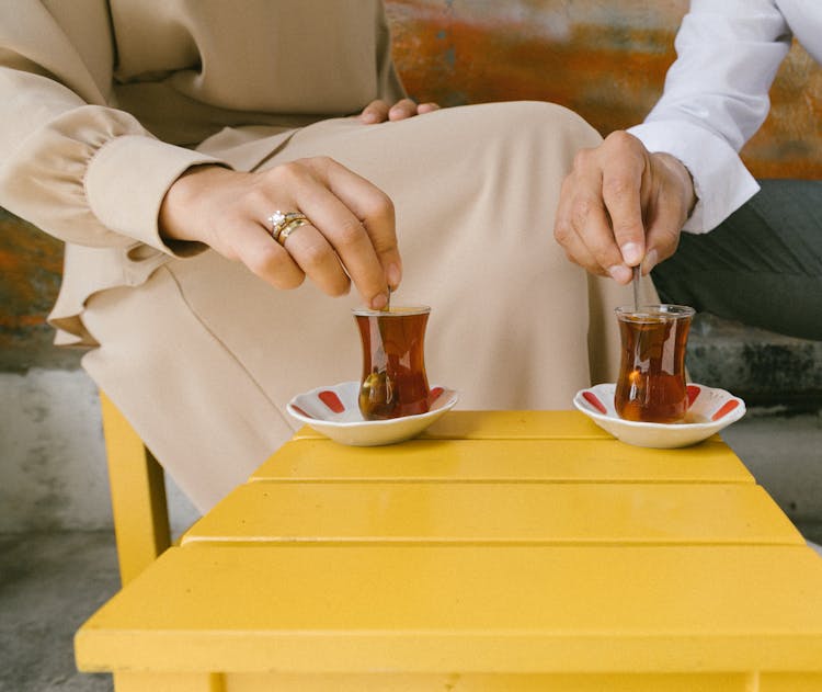 A Married Couple Mixing Their Tea Together