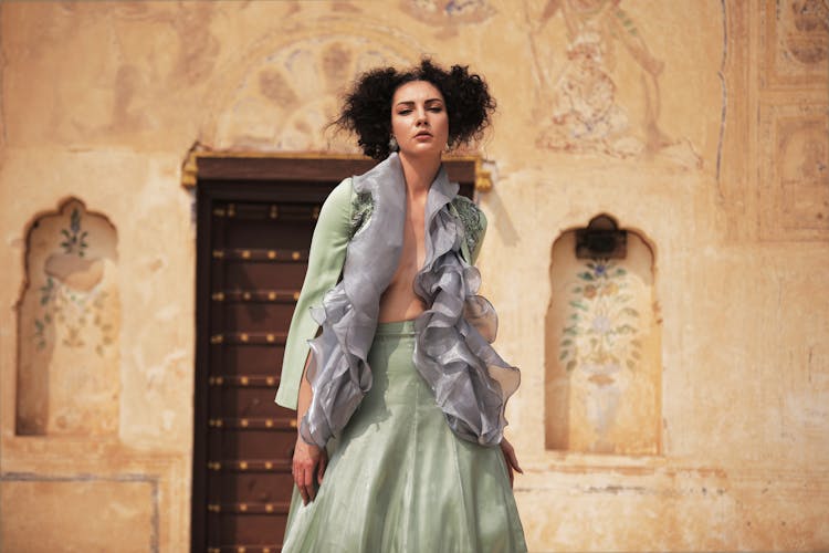 A Woman Wearing A Ruffle Top And A Green Long Skirt