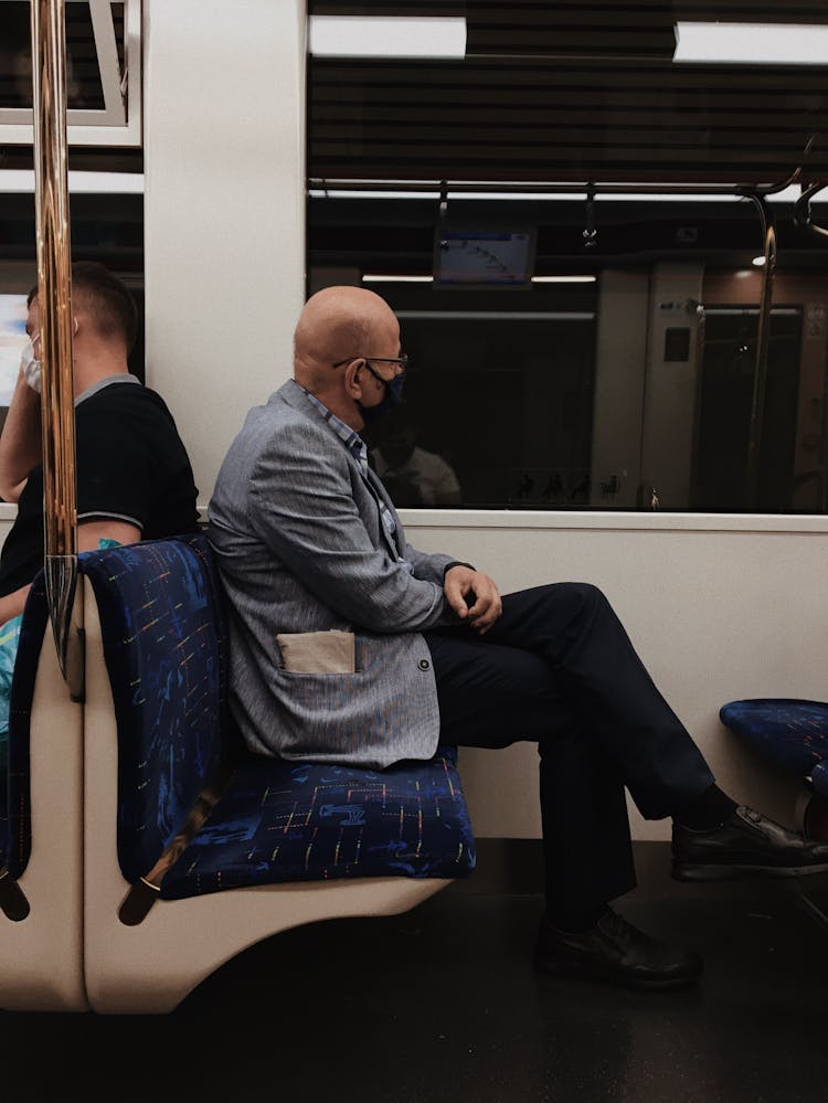 An Elderly Man Sitting On A Train