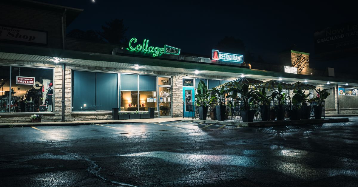 A nostalgic view of a commercial building with neon signs and a moonlit sky.