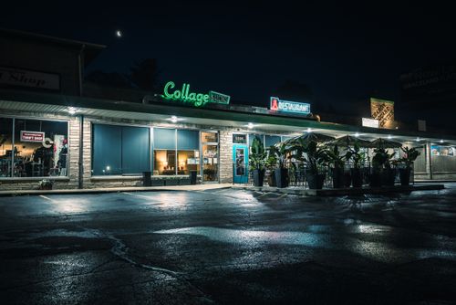 Free A nostalgic view of a commercial building with neon signs and a moonlit sky. Stock Photo