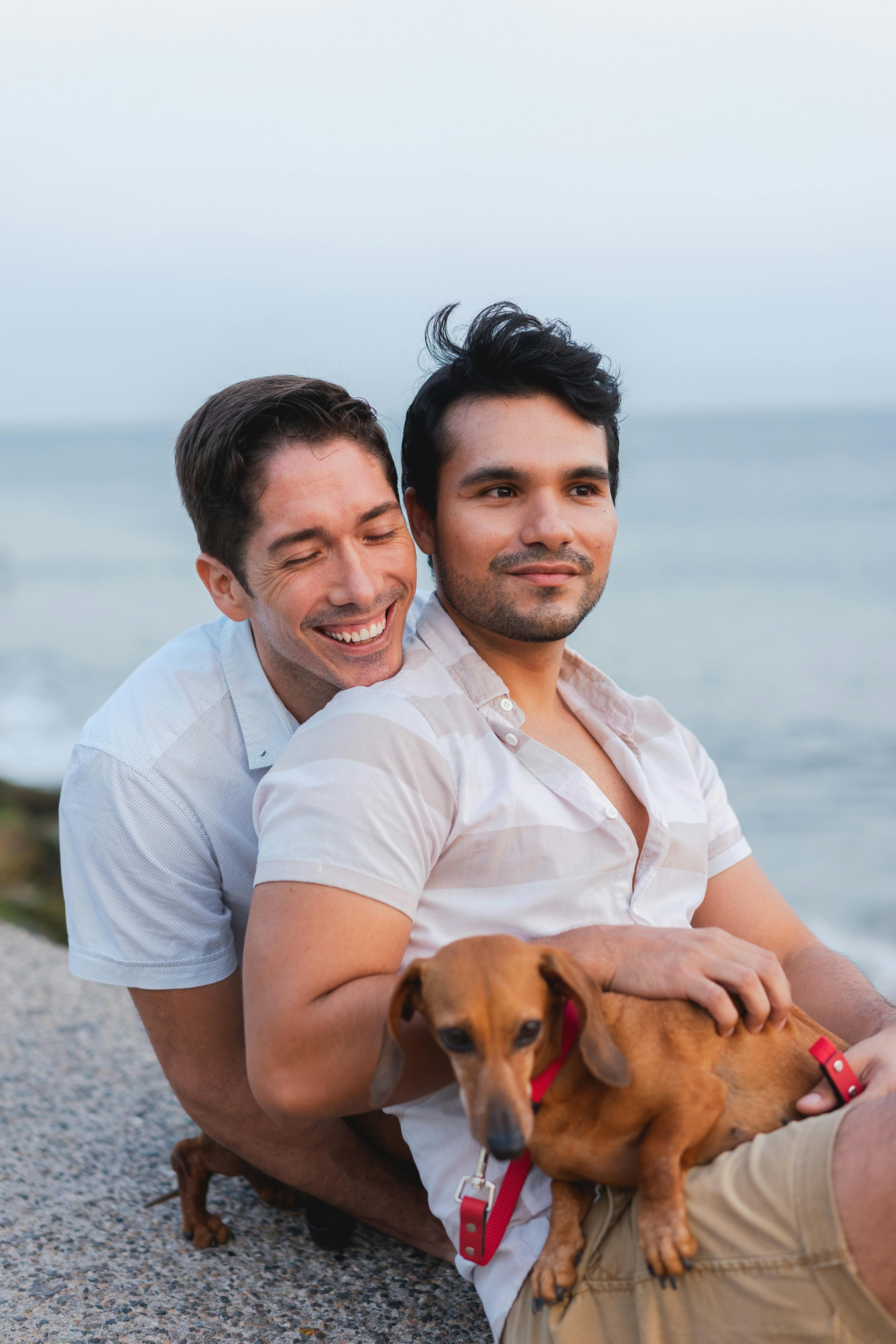 幸福的情侣与腊肠犬一起欣赏宁静的海滩景观