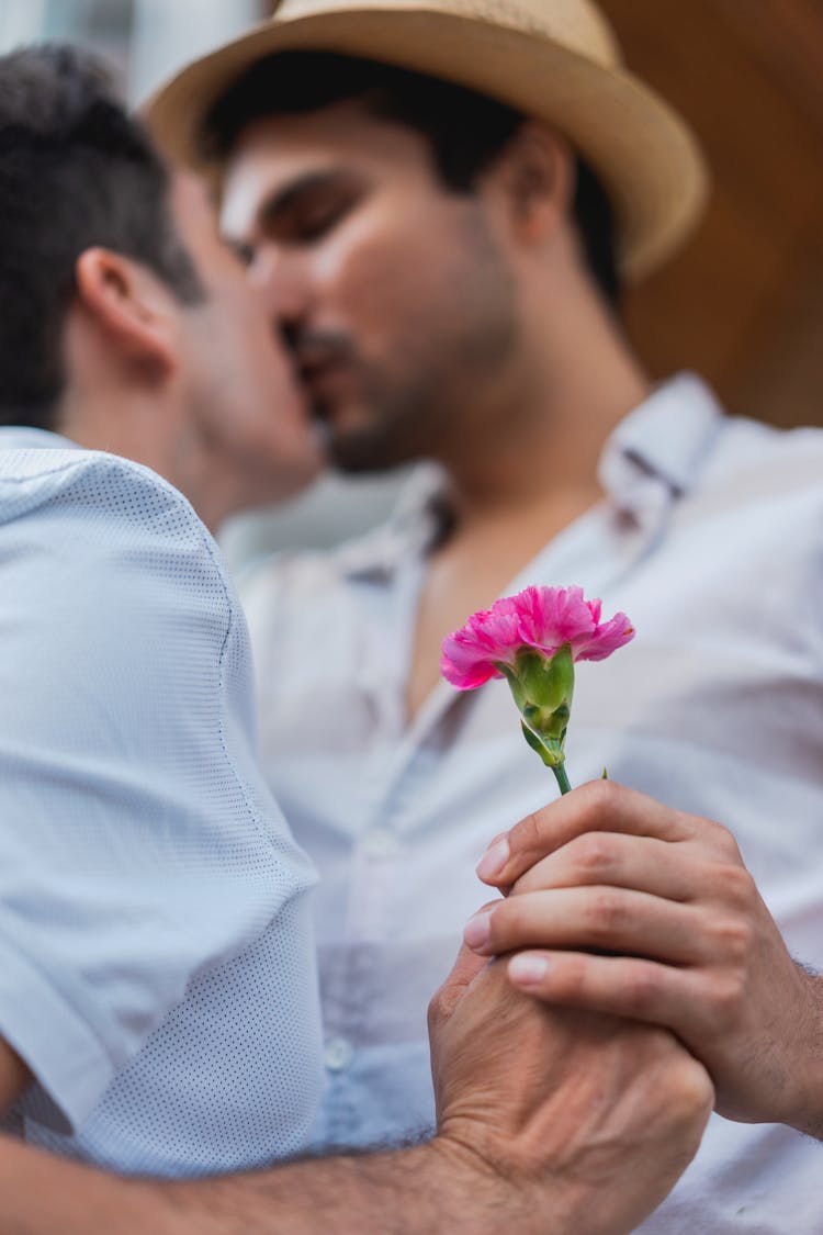 Gay Couple Kissing And Holding A Flower