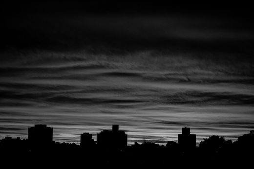 City skyline silhouette under a moody sky — photo by Lucas Pezeta on Pexels