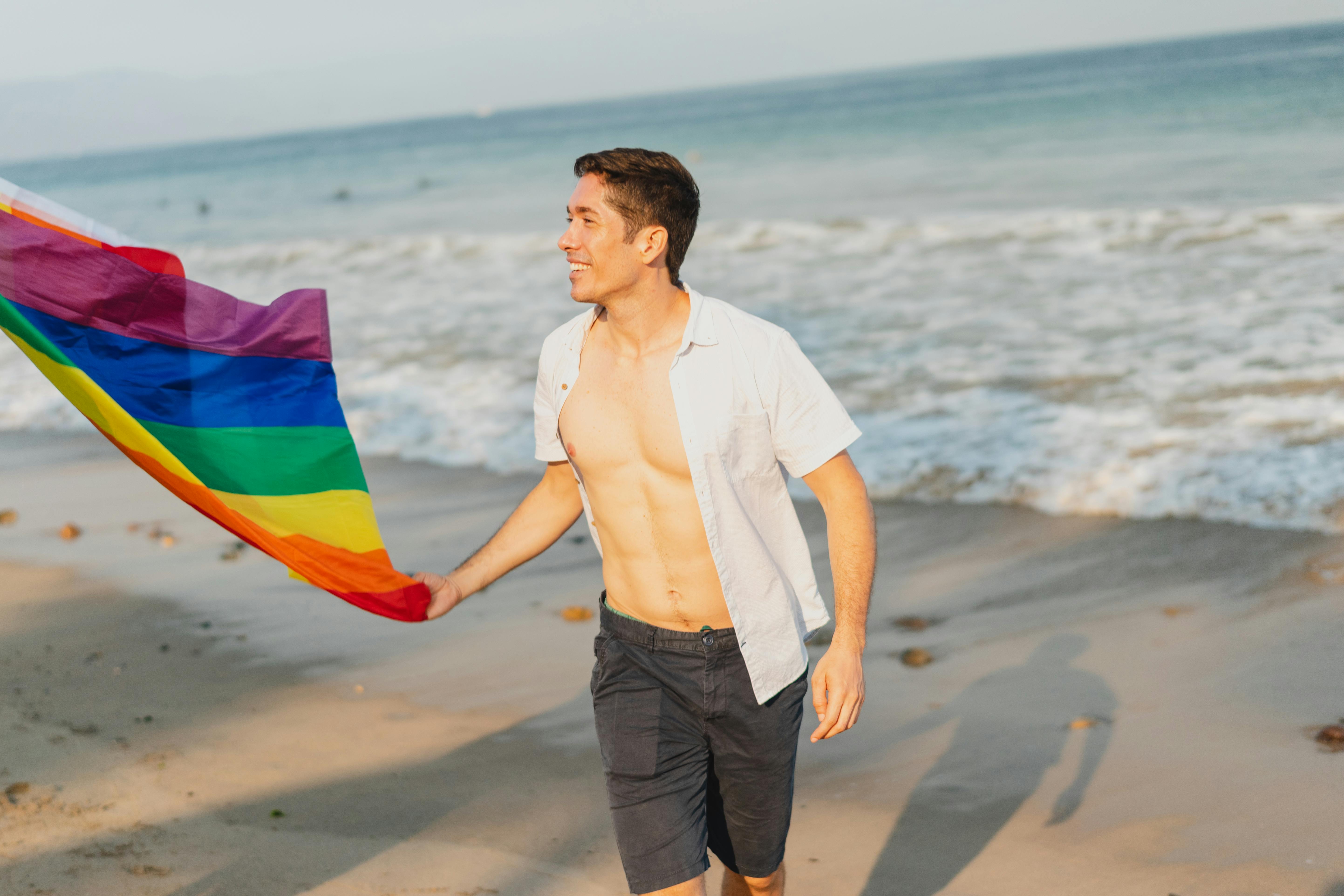 Man Holding a Gay Pride Flag · Free Stock Photo