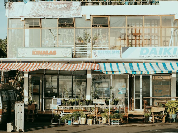 Facade Of A Building With Stores, Restaurants And Services In City 