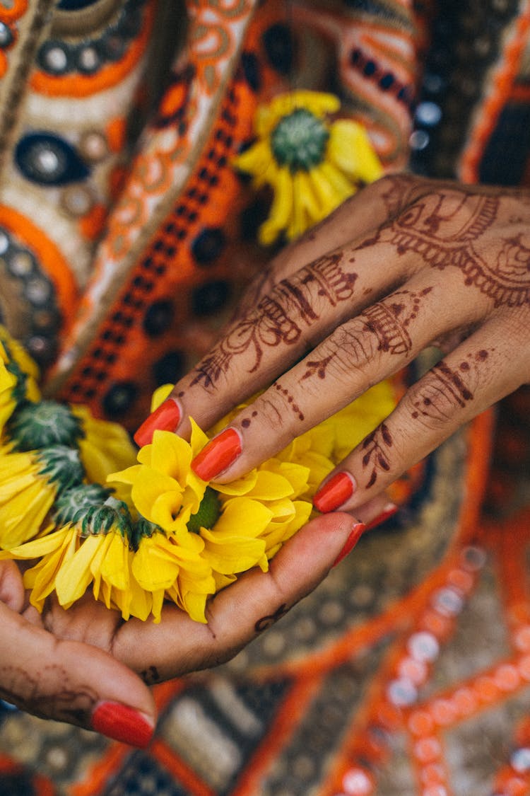 A Person With Henna Holding Yellow Flowers