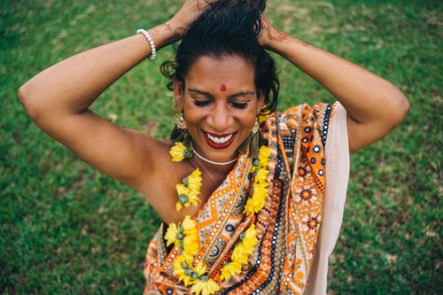 Free Smiling Indian woman in a saree and garland, celebrating outdoors in India. Stock Photo
