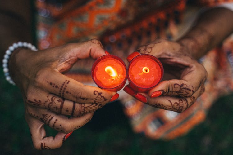 A Person With Henna Holding Candles 