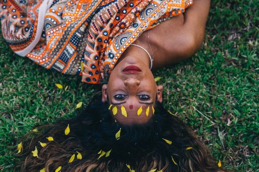 A Woman Looking Up while Lying on Green Grass Field