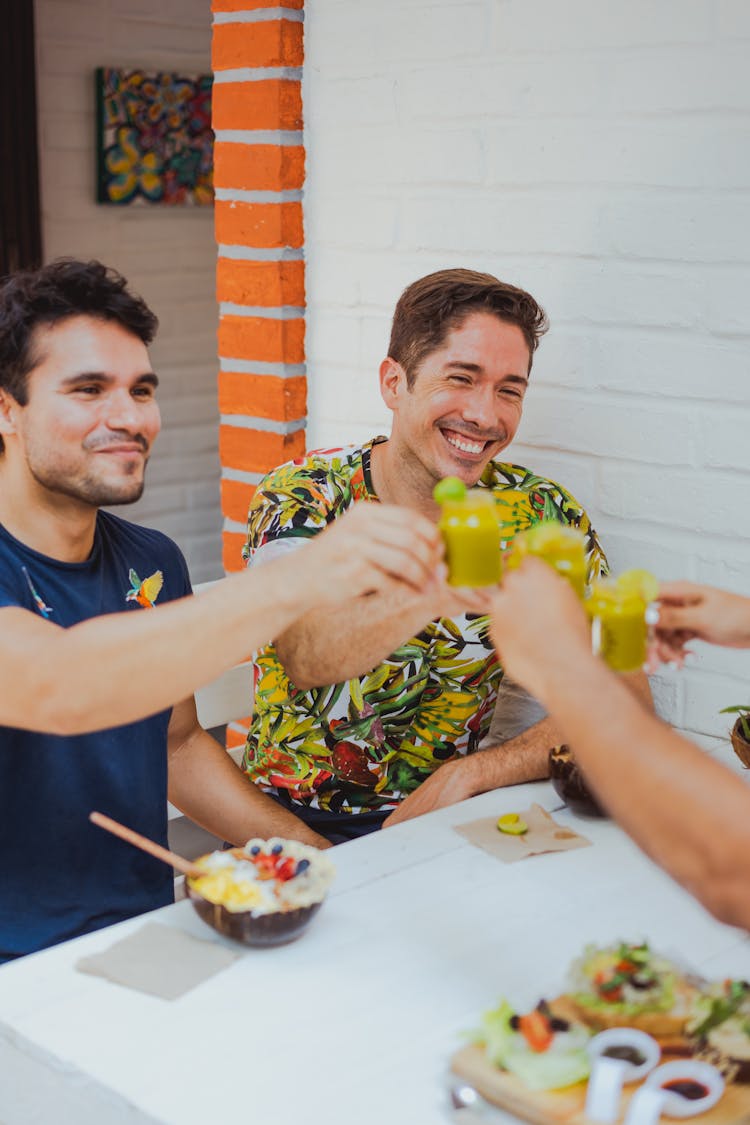 Group Of Friends Sitting At The Table In A Restaurant And Raising A Toast