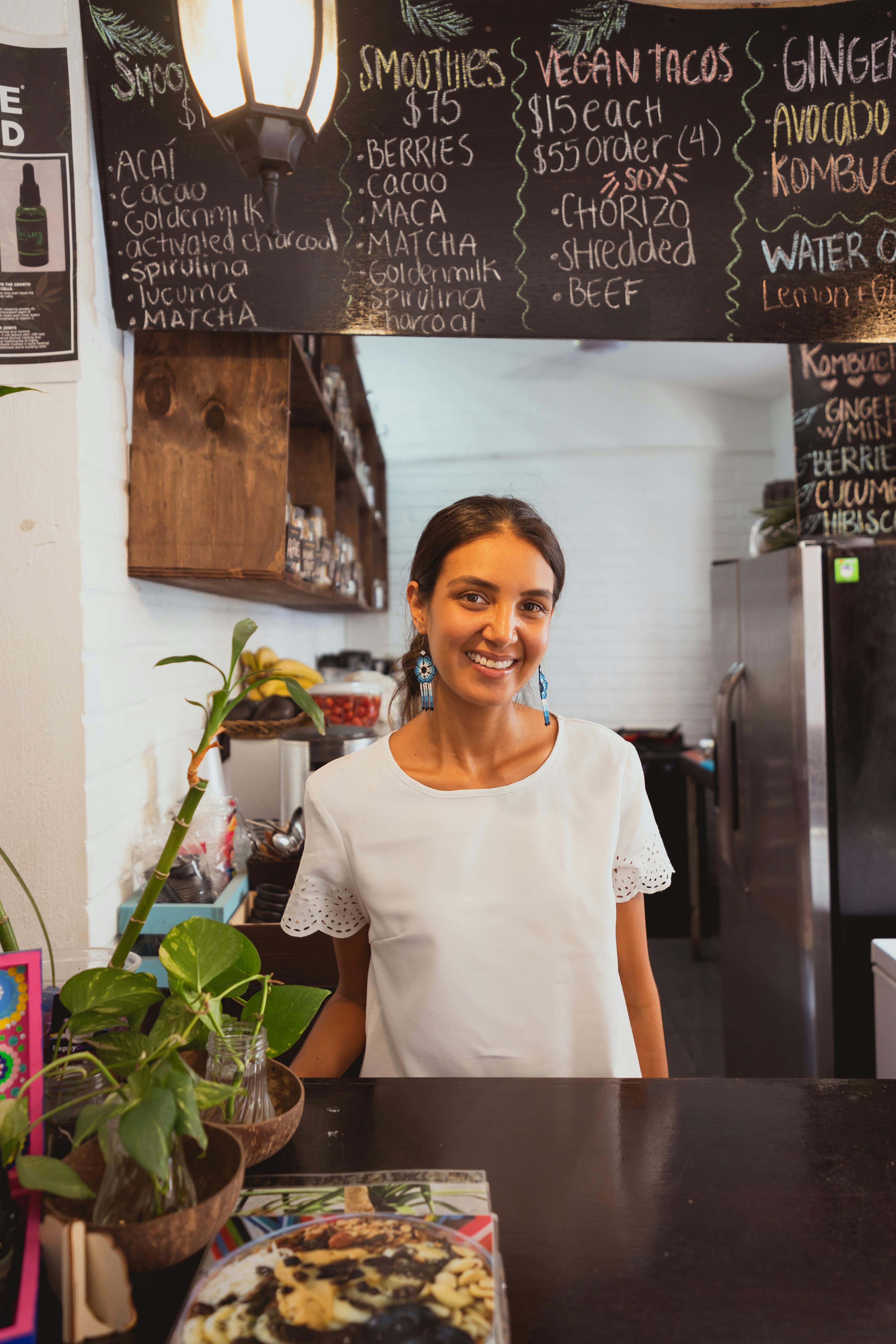 a happy woman behind a counter of a restaurant