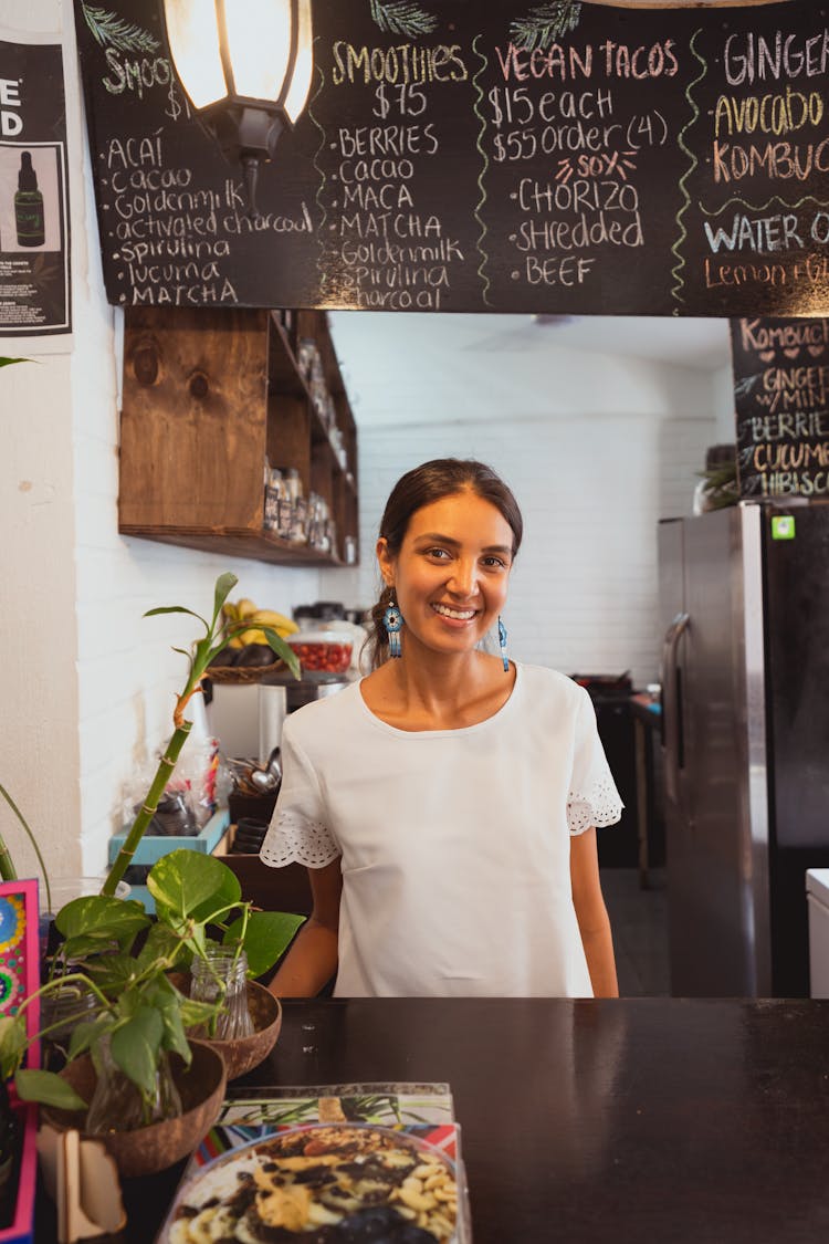 A Happy Woman Behind A Counter Of A Restaurant