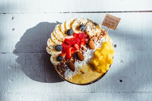 Free Indulge in this vibrant fruit smoothie bowl topped with banana, mango, and berries for a healthy treat. Stock Photo